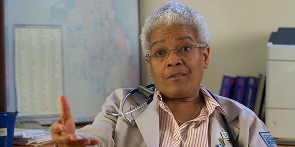 Black doctor speaking to camera