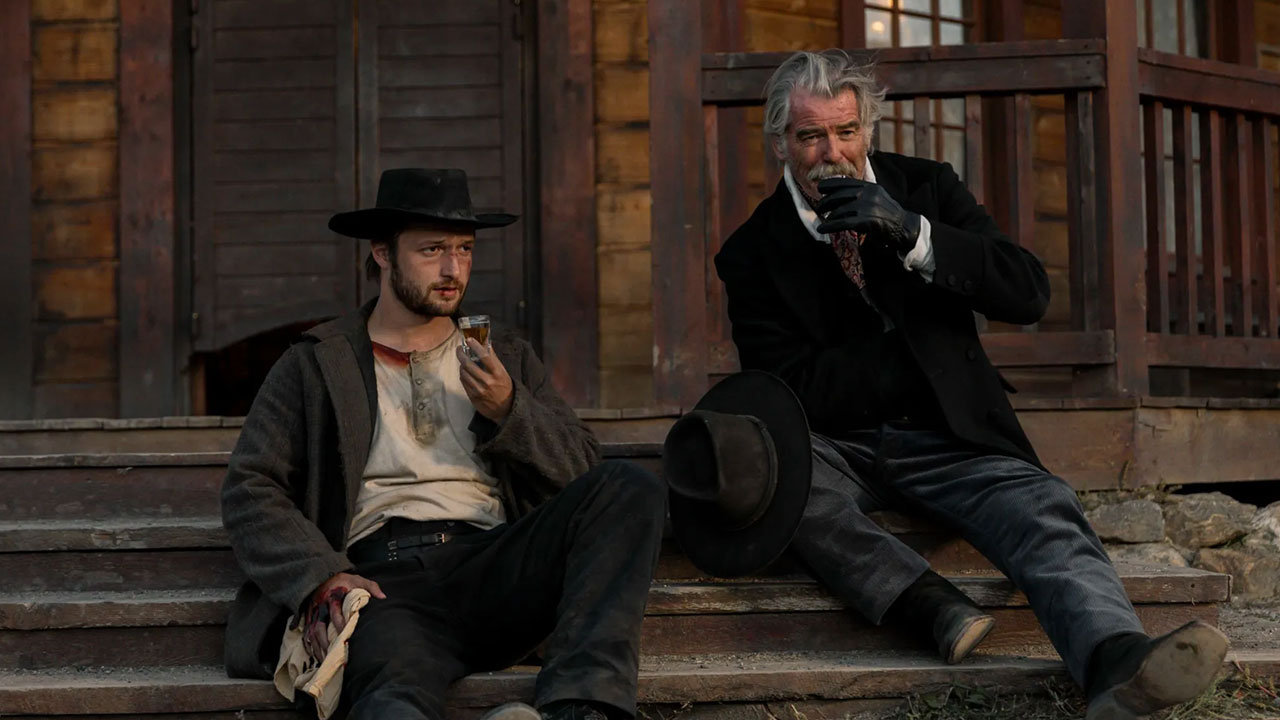 Two men dressed in western attire on porch steps