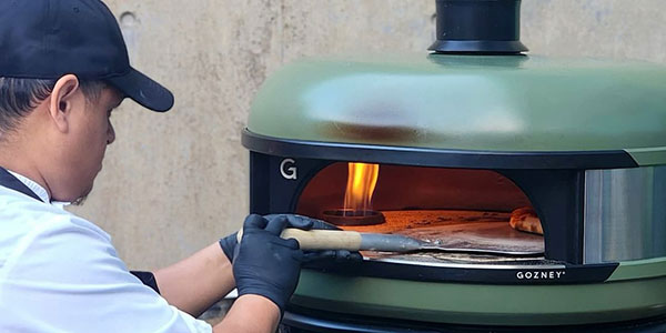 Cafe Modern staff making pizza in outdoor oven