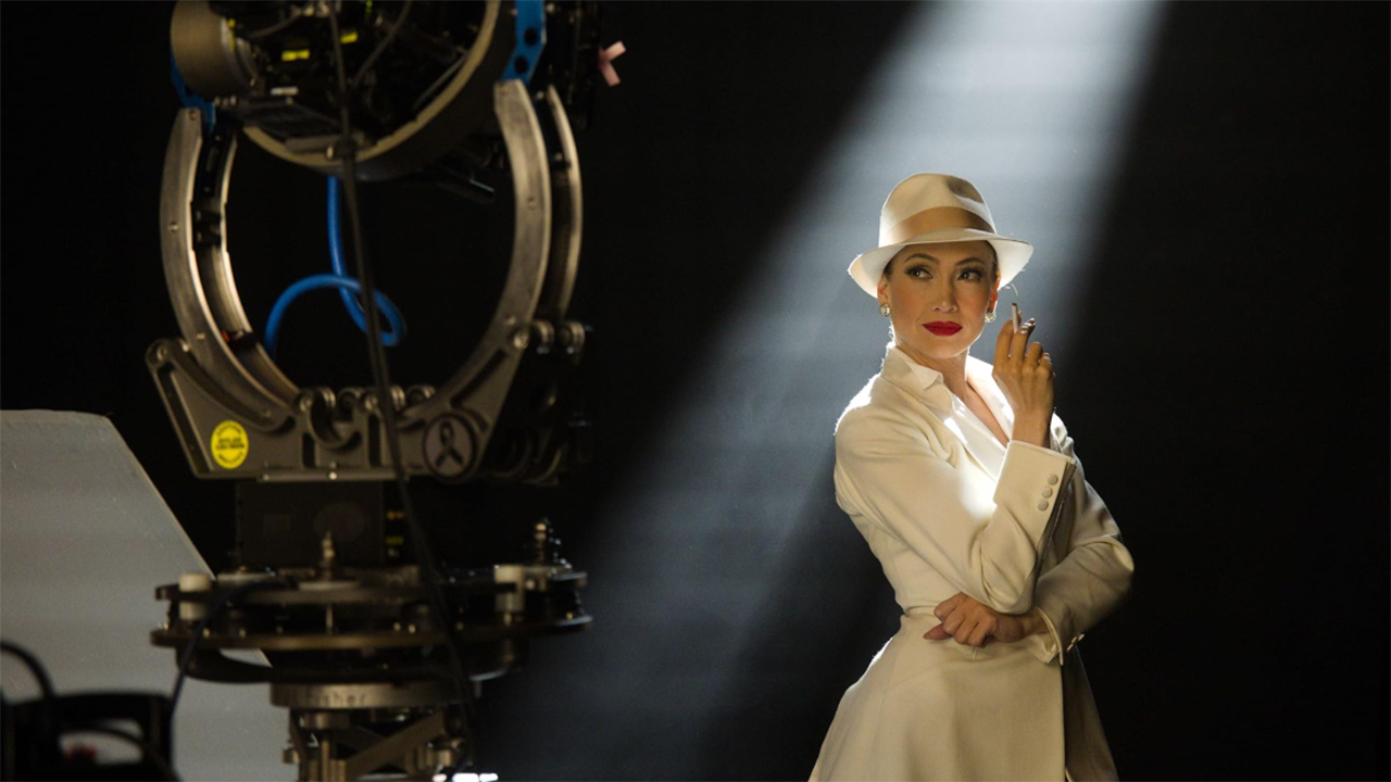 Jennifer Lopez in white suit and hat backstage