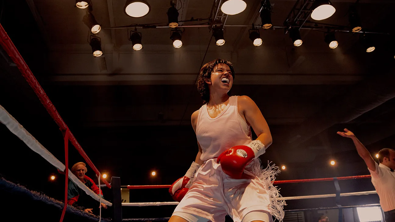 Brunette female boxer in ring with white outfit and red cloves