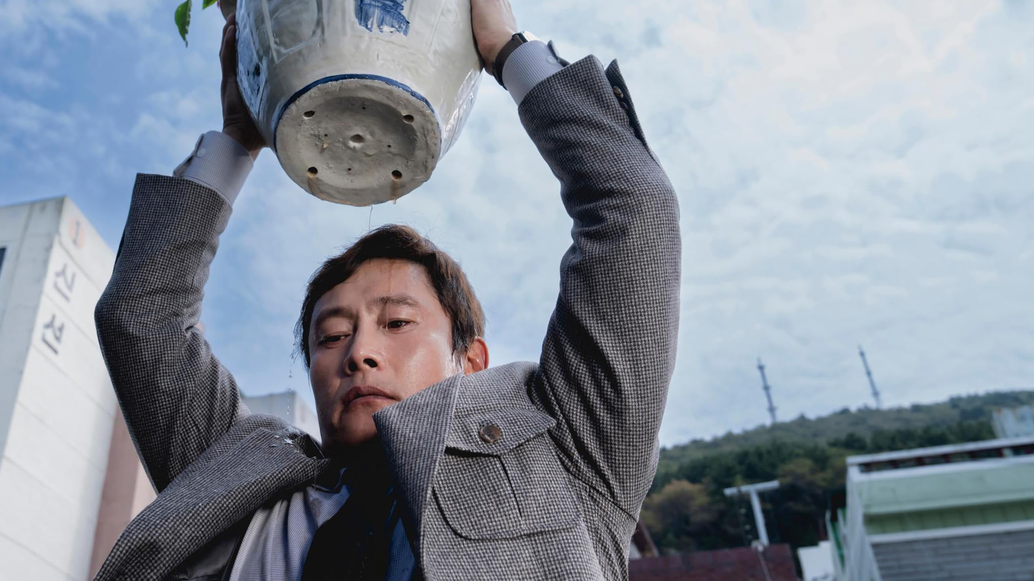 Asian man holding plant pot over his head