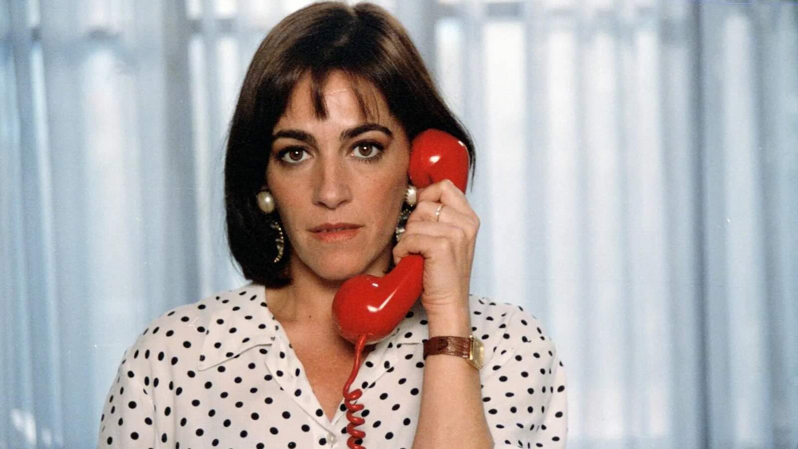 Woman answering a red telephone