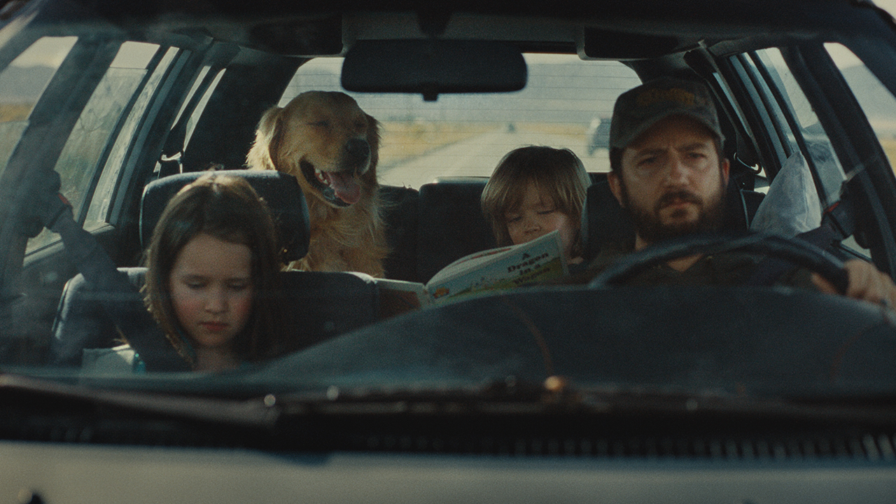 Father driving children and dog in car