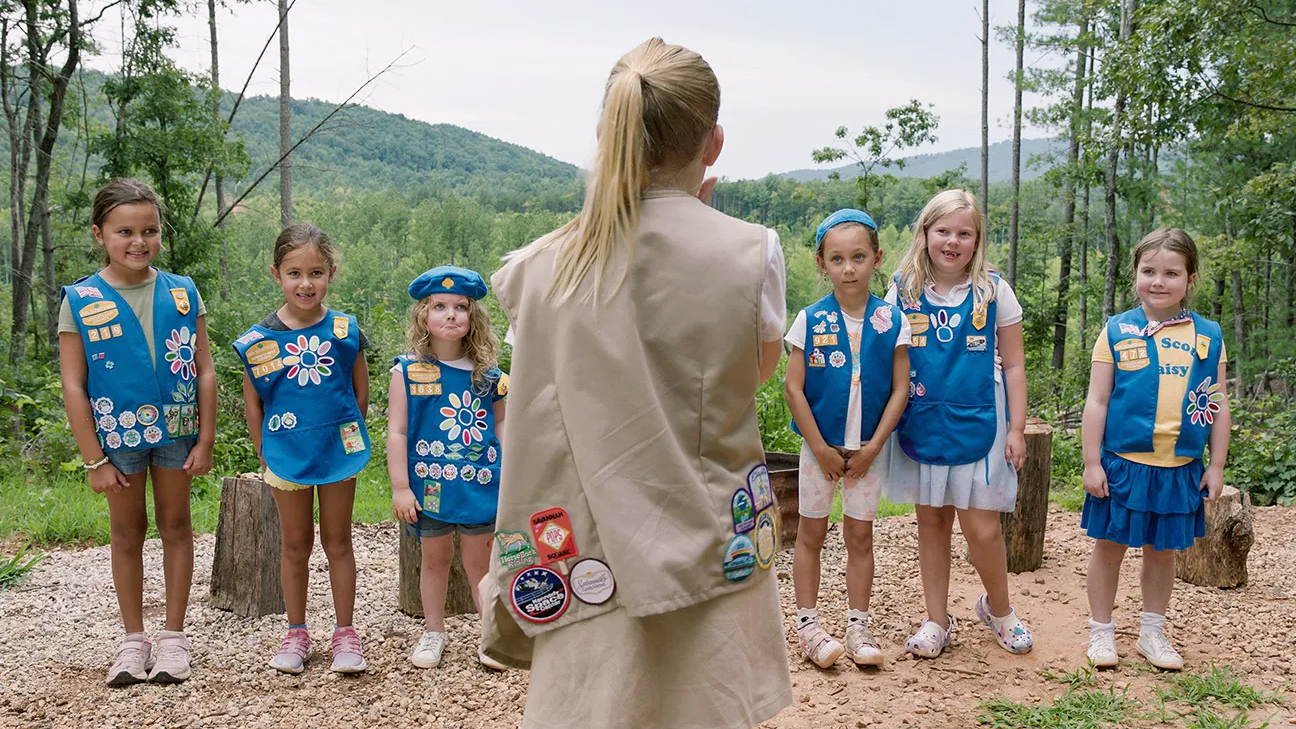 Young girl scouts listening to instructor in wilderness