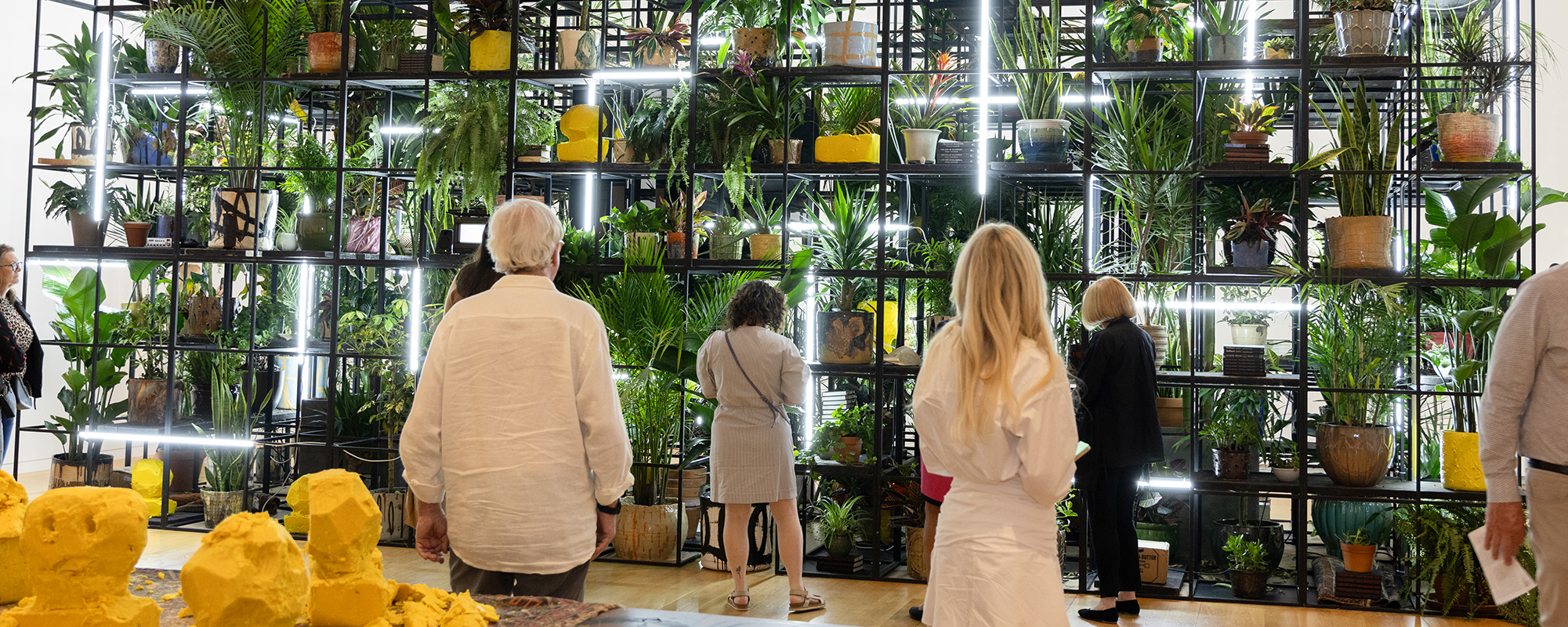 Group of people in front of large plant structure