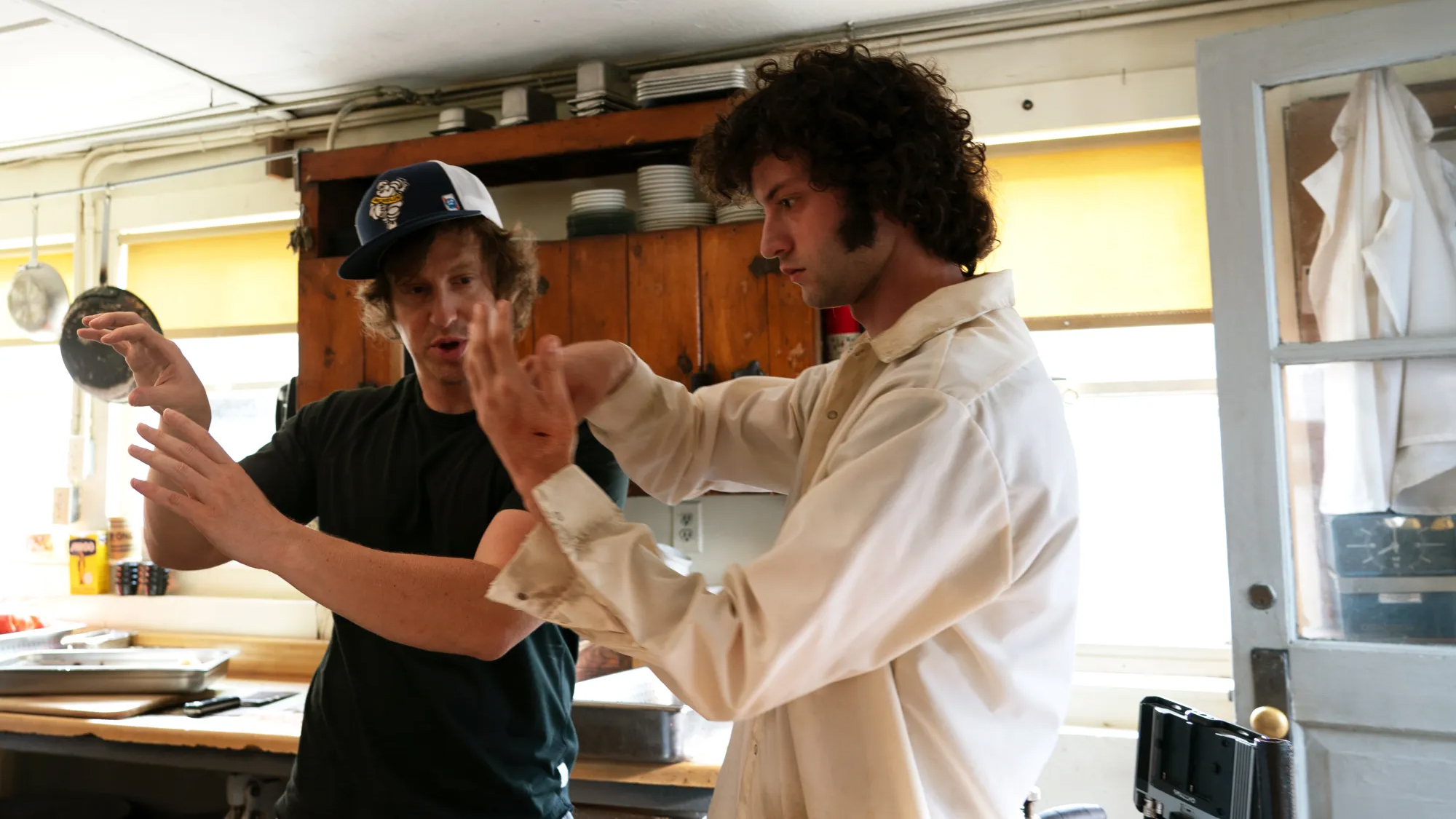 Two men in kitchen gesturing