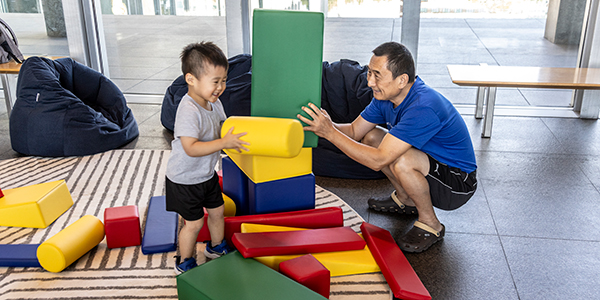 Asian man and child playing with blocks