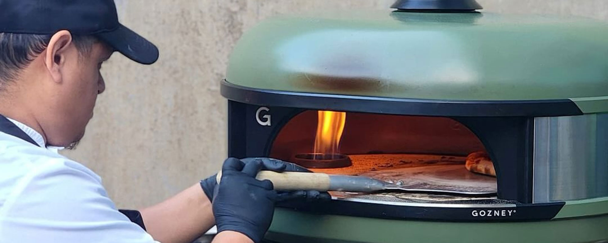Cafe Modern staff making pizza in outdoor oven