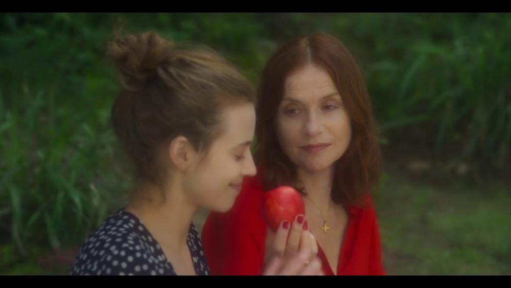 two_women_seated_one_holding_apple